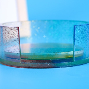 Macro detail of red and blue gradient resin coaster holder with sparkling glitter finish