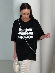 Detail of black oversized cotton t-shirt featuring white Bonjour Madame printed text