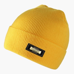Dettaglio di un berretto in maglia a coste giallo acceso con placca in metallo fashion