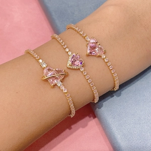 Golden bracelet set featuring pink heart zircon and floral bow designs on a wrist