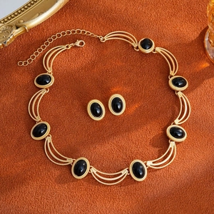 Vintage gold-tone jewelry set featuring black oval gemstones and textured floral design