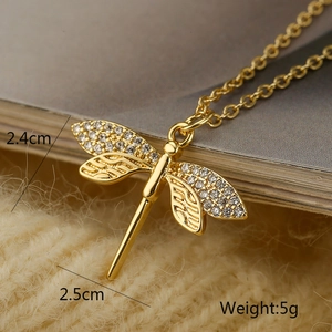 Detailed view of gold dragonfly pendant with dimensions 2.4cm x 2.5cm and 5g weight