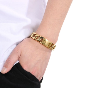 Close-up of a gold Cuban link chain bracelet with a smooth rectangular clasp on a wrist