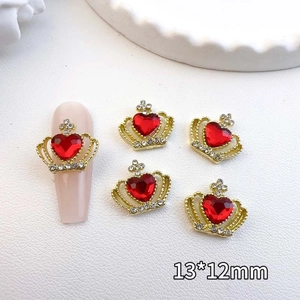 Macro shot of 13x12mm golden crown nail charms with red heart jewels and small crystals