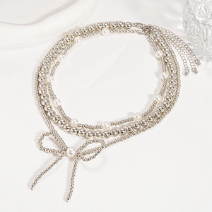 Three-layer faux pearl beaded necklace with silver beads and a central bow pendant
