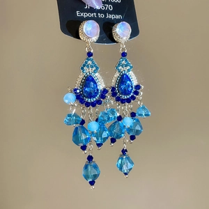 Macro detail of blue crystal tassel earrings with sparkling gemstones and silver finish
