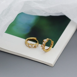 Detail of gold-plated silver huggie hoop earrings with square and round cubic zirconia
