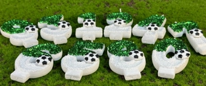 Macro de bougies d'anniversaire football 0-9 avec paillettes vertes sur fond d'herbe
