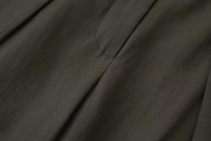 Vue détaillée de la texture du tissu sergé olive foncé et de la qualité des coutures