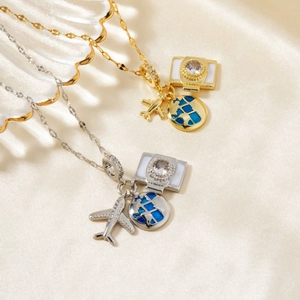 Detail of travel themed necklaces with plane, globe, and camera pendants in silk setting