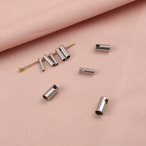 Vue détaillée des perles à écraser en acier inoxydable sur un tissu en soie rose