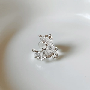 Macro shot of 925 sterling silver ring with textured irregular surface and wavy design