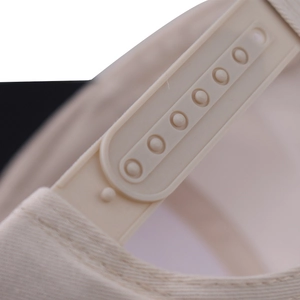 Détail de la fermeture snapback ajustable en plastique sur casquette de baseball beige