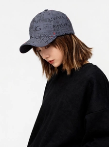 Detail of dark grey baseball cap with black graffiti letters and cotton twill texture