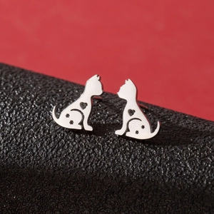 Silver cat stud earrings with hollow heart and star details on red and black background