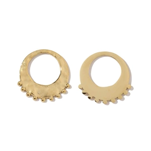 Détail macro de boucles d'oreilles dorées à texture martelée et perles de style bohème