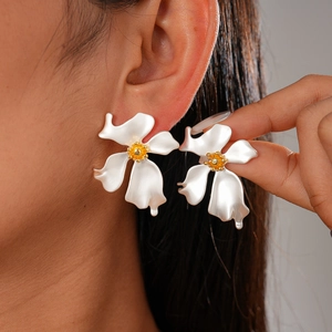 Vintage-Stil weiße Blumen-Ohrstecker mit goldener Mitte, von Model getragen