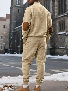 Detail of men's knit set showing beige high neck sweater with brown elbow patches in street