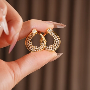 Close-up of gold plated flower hoop earring with pavé-set cubic zirconia crystals