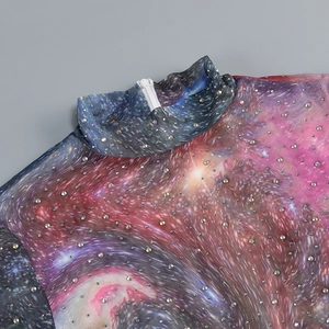 Détail du tissu en maille imprimé galaxie avec strass scintillants et fermeture éclair au dos