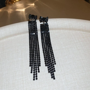 Detailed view of elegant black bow earrings with shimmering diamond-encrusted fringe chains