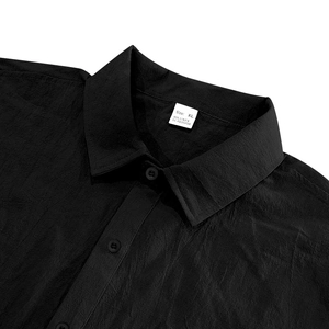 Close-up of black linen shirt collar showing fabric texture and material label