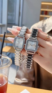 Detail of square quartz watches with ceramic metal bands and sparkling diamond bezel