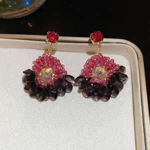 Detailed macro view of vintage court style earrings with red gemstones and purple sequins