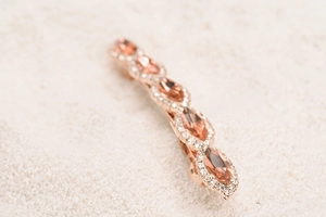 Macro shot of rose gold spring hair clip with peach marquise crystals and rhinestones