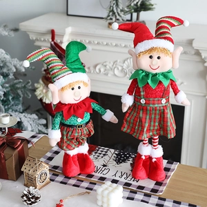 Standing plush Christmas elf dolls with retractable legs next to a festive fireplace