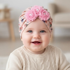 Detailed close-up of pink baby turban hat with floral 3D fabric flowers and pearls
