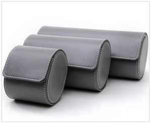 Three sizes of gray leather watch rolls with white stitching details for storage
