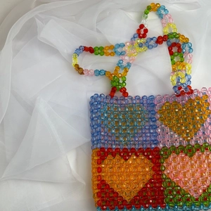Close-up of colorful heart pattern beads and textured acrylic weave on a tote bag