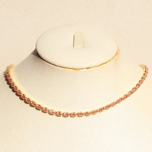 Gold plated jewelry set with oval pink cubic zirconia stones on a beige mannequin