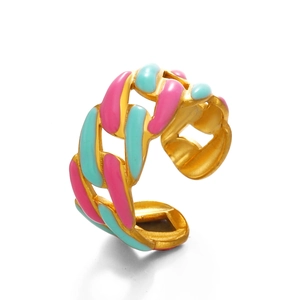 Golden chain link ring with pink and blue enamel detailing on a clean white background
