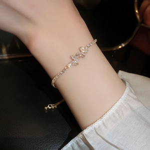 Close-up of elegant zircon butterfly bracelet worn on wrist with adjustable gold-tone chain