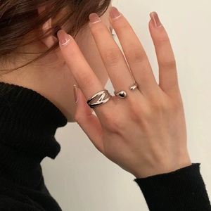 Layered crisscross and C-shape silver rings for women shown on a model hand