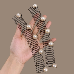 Detalle de dos peines de metal con perlas y bordes dorados para el peinado del cabello