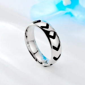 Gros plan détaillé d'une bague minimaliste en acier inoxydable argenté avec motif de flèches
