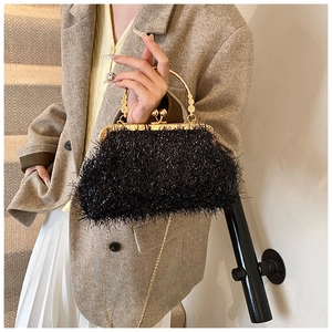 Détail du sac de soirée en peluche noire avec cadre doré et poignée anneau ornée