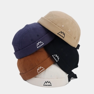 Détail de bonnets dockers rétro avec broderie de montagne et sangles de réglage