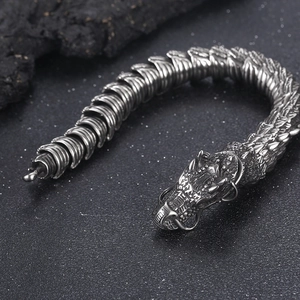 Macro shot of silver dragon steel bracelet with detailed scales and dragon head clasp