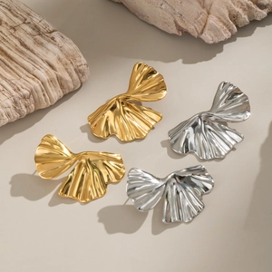 Ginkgo leaf stud earrings in gold and silver finish on a natural stone display