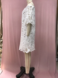 Detailansicht der weißen floralen Lochstickerei und Spitze am Sommerkleid