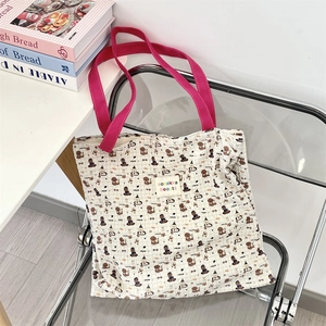 Detail of cute puppy print canvas tote with pink handle and woven logo patch