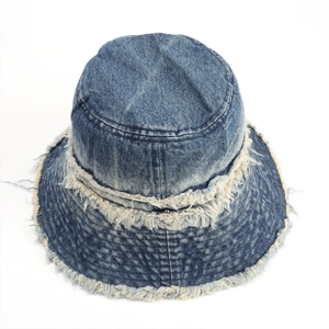 Close-up of distressed edges and layered denim fabric on a blue wash fisherman hat