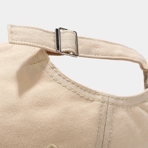 Close-up of khaki cotton baseball cap featuring an adjustable metal buckle and neat stitching
