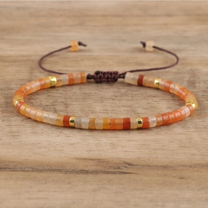 Detail of adjustable woven imperial stone bracelet with orange and red beads