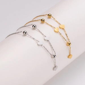 Minimalist 18K gold and silver heart tassel necklaces displayed on white curved stand