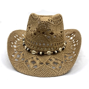 Hollow out straw cowboy hat with shell bead band shown on white background